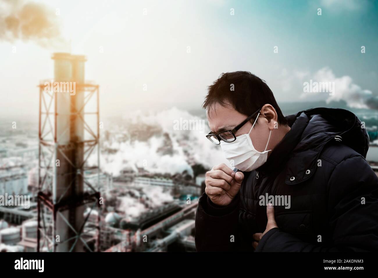 Uomo che indossa maschera contro smog e inquinamento atmosferico sfondo in fabbrica Foto Stock