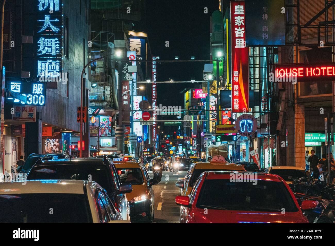 Le luminose insegne illuminate fiancheggiano le strade mentre il traffico si intronda nel centro di Taipei, Taiwan Foto Stock
