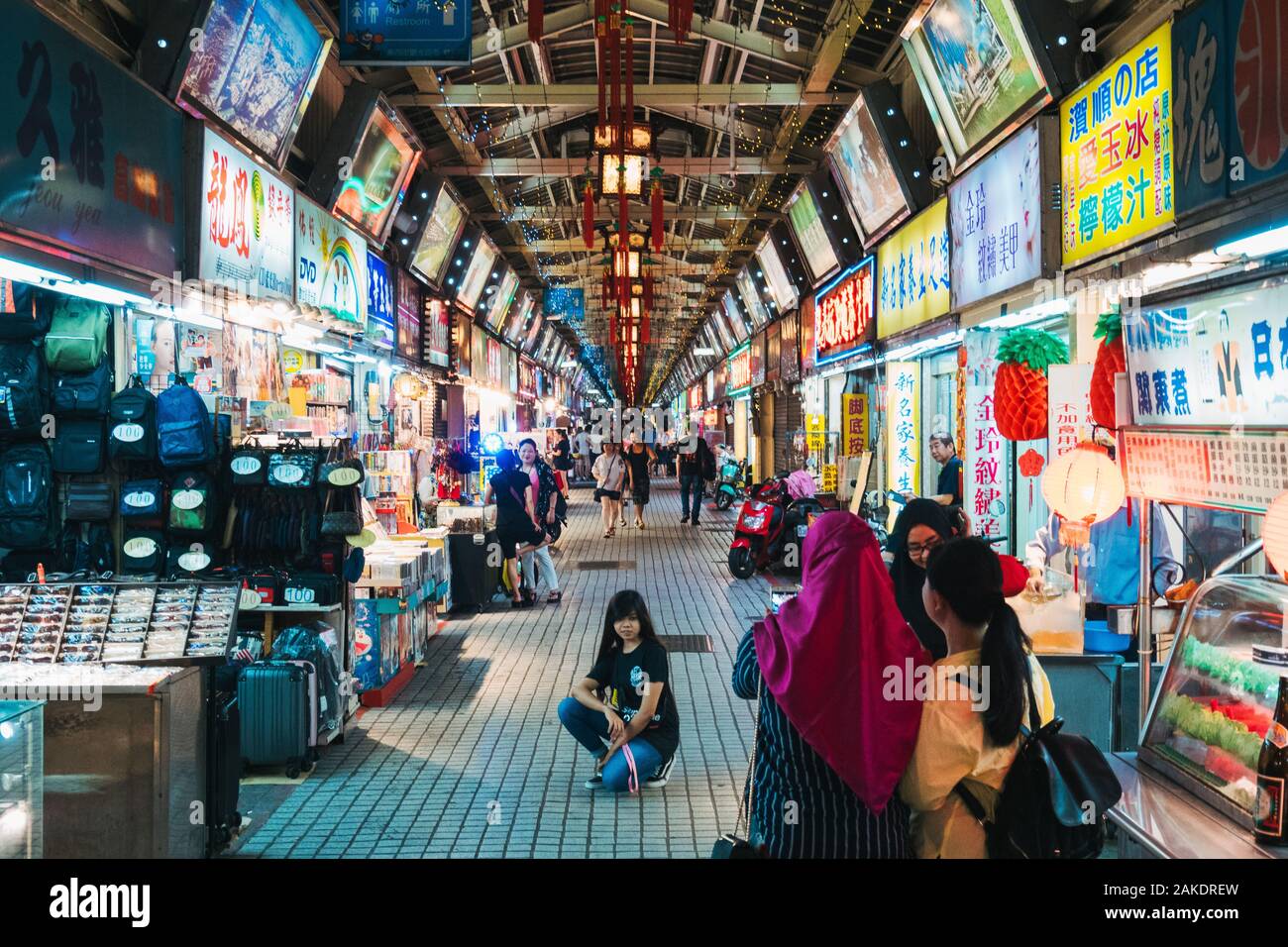 I turisti musulmani posano per una foto in un tranquillo e vuoto Huaxi Street Night Market, all'orario di chiusura, Taipei City, Taiwan Foto Stock