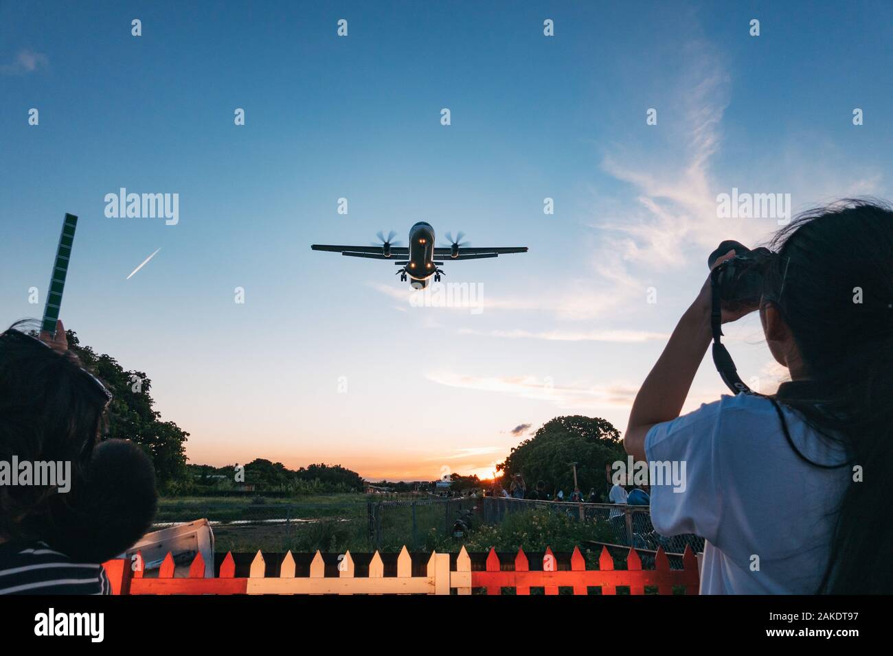 Planespotters line Airplane Alley, telecamere pronte, come un ATR 72 turboprop rende un approccio al Taipei Songshan Airport Foto Stock