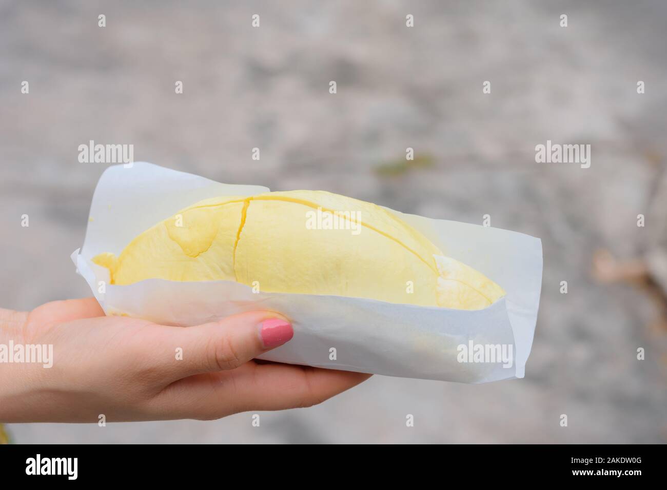 La mano di una donna tenendo un durian Foto Stock