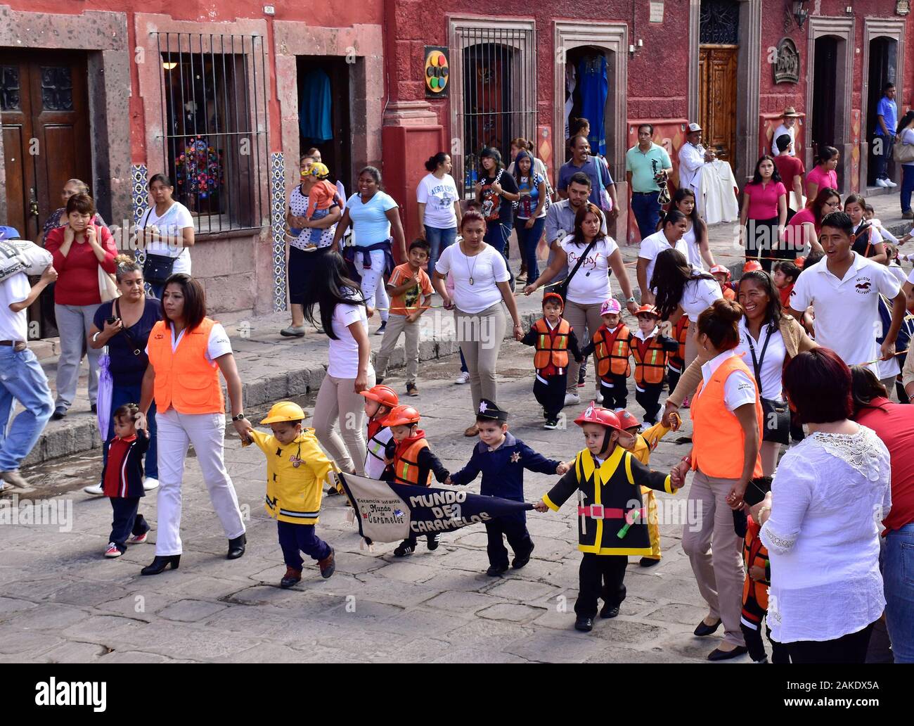 Figli messicani in parata in piazza locale. Gli edifici che la circondano El Jardín Allende Park di San Miguel De Allende, Messico. Sito del Patrimonio mondiale. Foto Stock