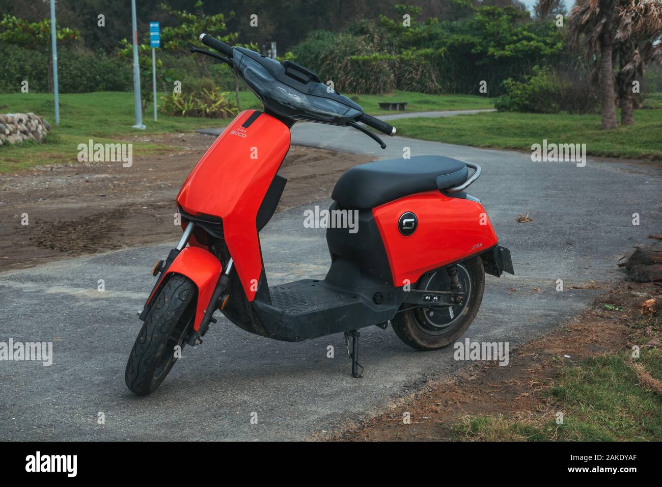 Un rosso Super Soco CU scooter elettrico parcheggiato su un percorso in Qijin parco costiero, Qijin Isola, Kaohsiung, Taiwan Foto Stock
