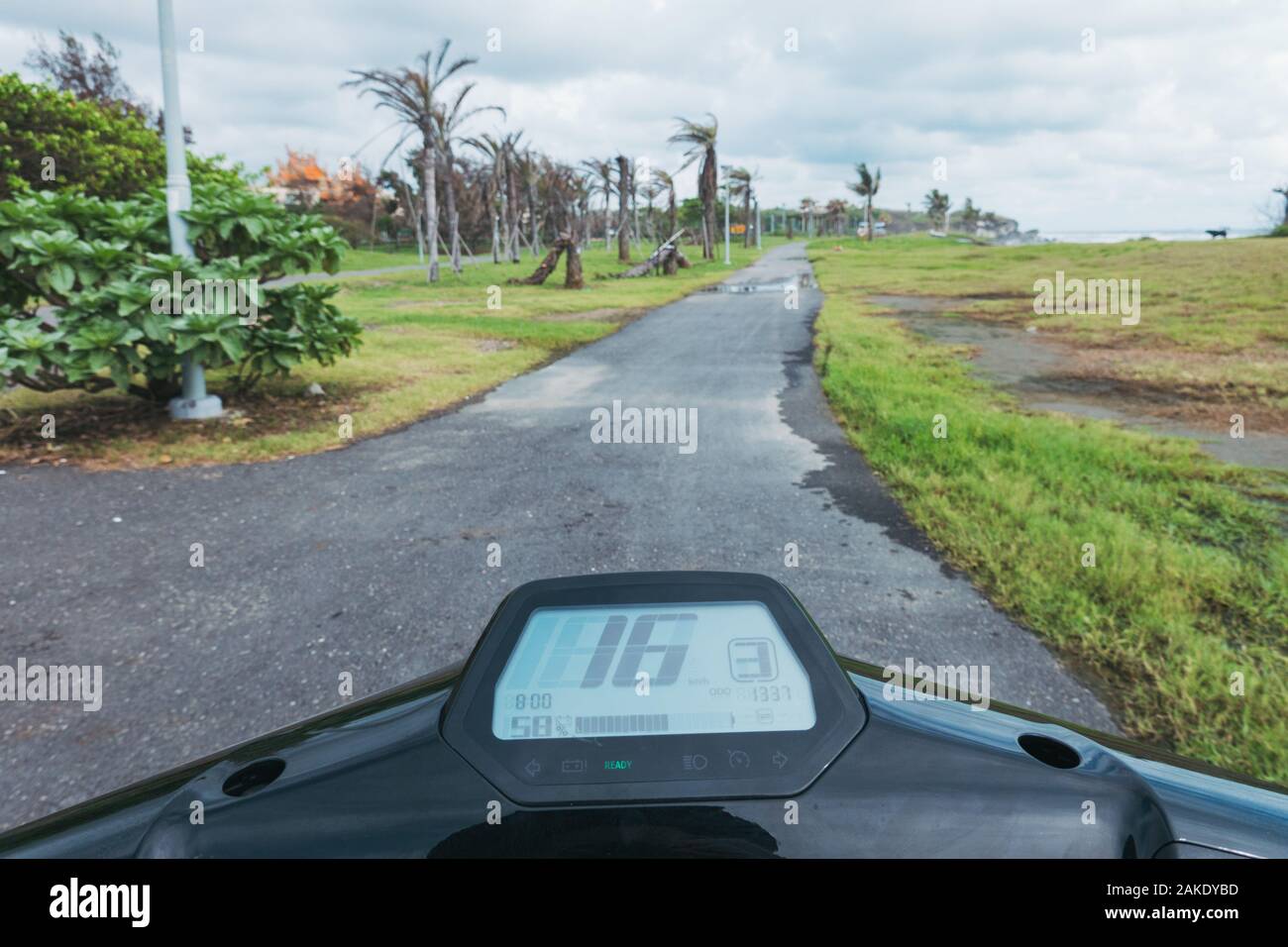 In sella a una super Soco CU scooter elettrico lungo la passerella in Qijin parco costiero, Kaohsiung, Taiwan Foto Stock