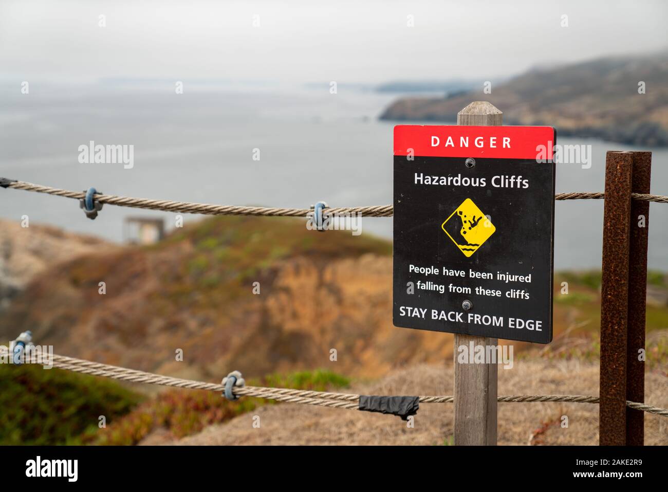 Pericolo scogliere pericolose rimanere indietro dal bordo segno sulla fune di sicurezza Avvertenza confine i visitatori in un percorso a piedi Foto Stock