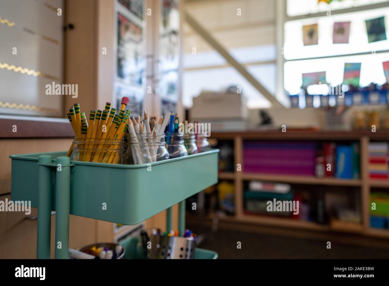 Teal carrello riempito con vasi di matite colorate per una scuola elementare classe d'arte Foto Stock