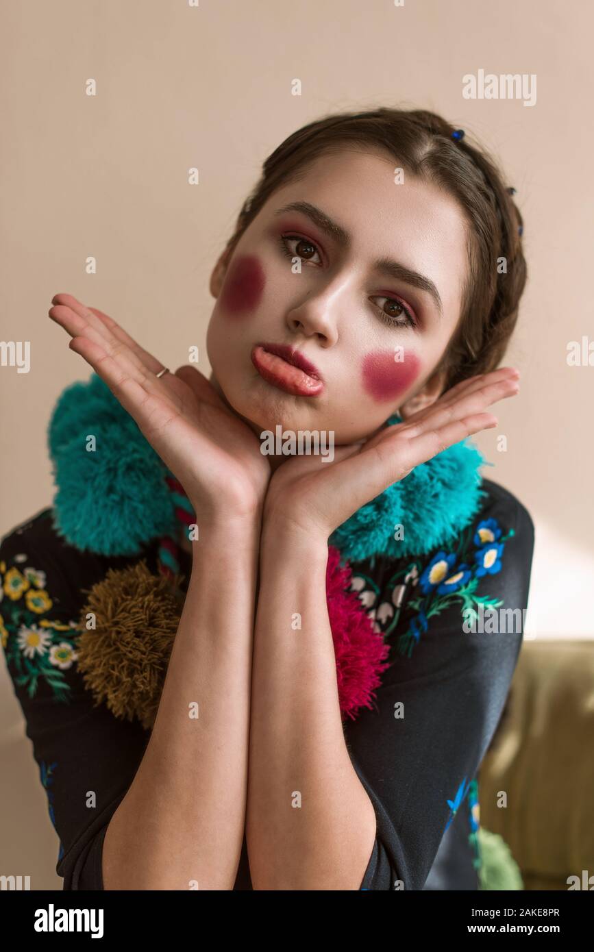 Moda bella bruna ragazza felice in una tuta con ricami floreali con colori makeup: le guance rosse e le labbra. La Granny chic stile. Ritoccate po Foto Stock