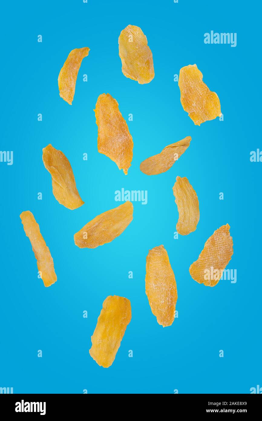 Flying mango chip su un sfondo turchese. Battenti di frutta. Verticalmente. Foto Stock