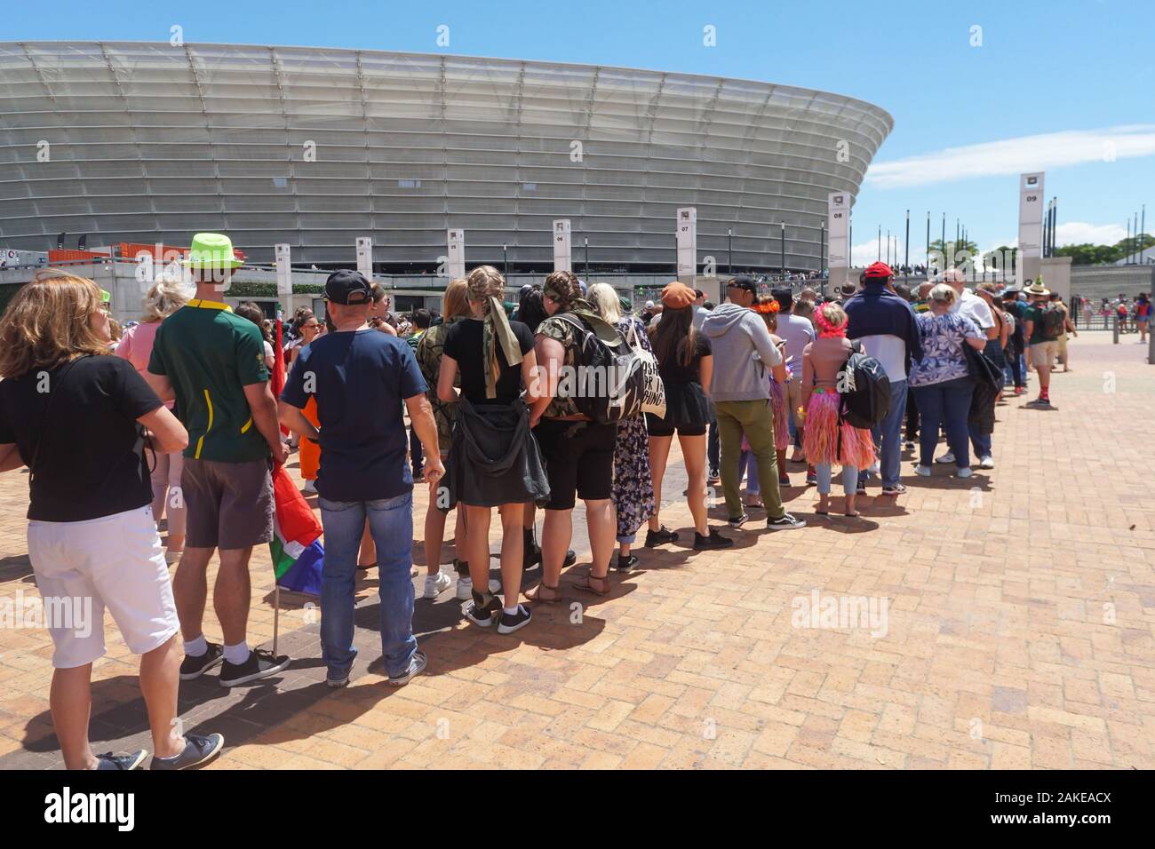 Persone, ventole, sostenitori di international torneo internazionale di rugby a sette formano una coda al di fuori del Cape Town Stadium nel punto verde per il giorno finale corrispondono Foto Stock