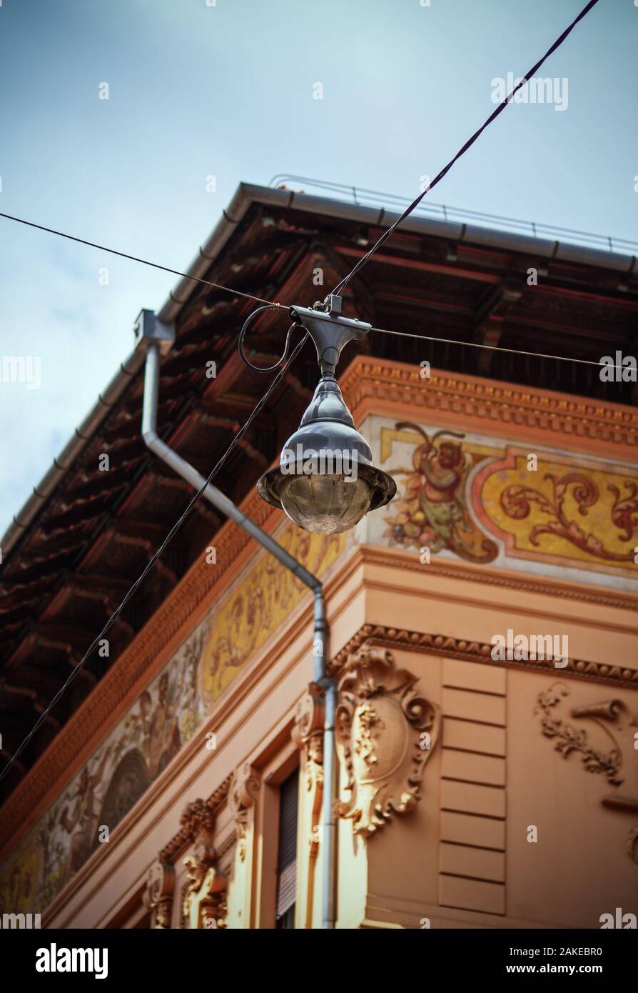 Vecchia strada vintage lampada su attraversamento di fili di antenna appesa sopra la strada con un bel vecchio edificio con architettura ornamentali in background Foto Stock