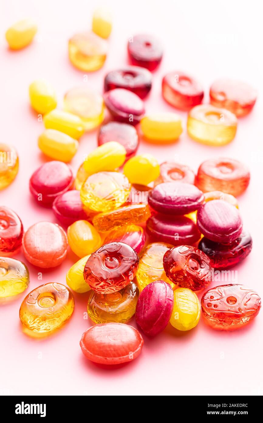 Dolci caramelle colorate su sfondo rosa. Foto Stock