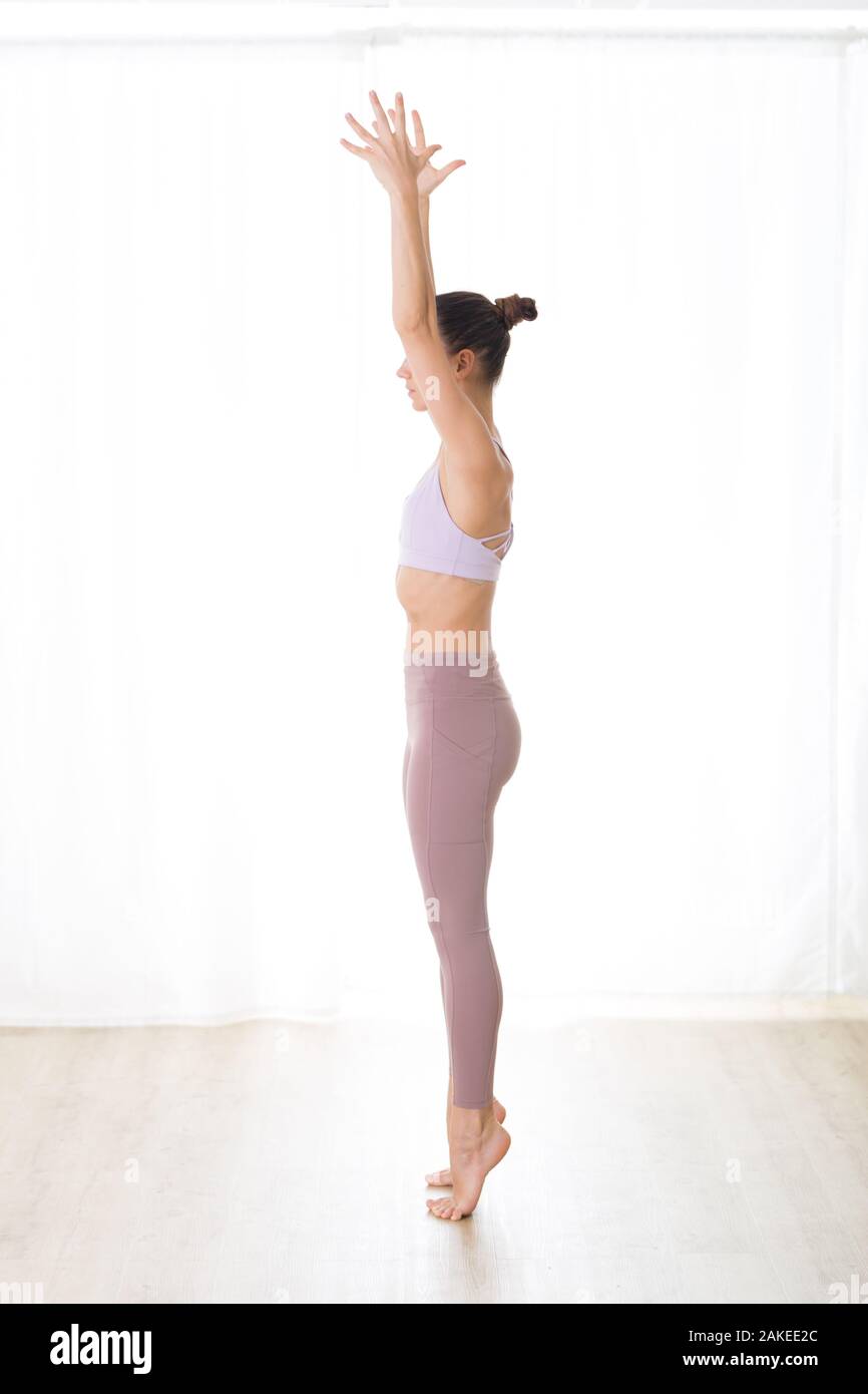 Ritratto di splendida sportiva attiva giovane donna a praticare yoga in studio. Bella ragazza pratica Dandayamana Bibhaktapada Paschimotthanasana Foto Stock