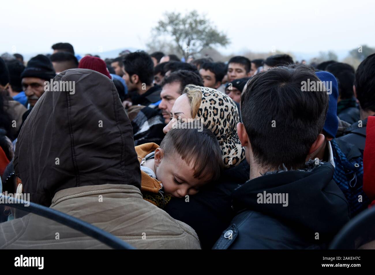 Una donna Siro trattiene il suo Figlio come rifugiati attendere per passare il greco confine macedone all'interno dell'improvvisato campo profughi di Idomeni nel nord della Grecia. Foto Stock