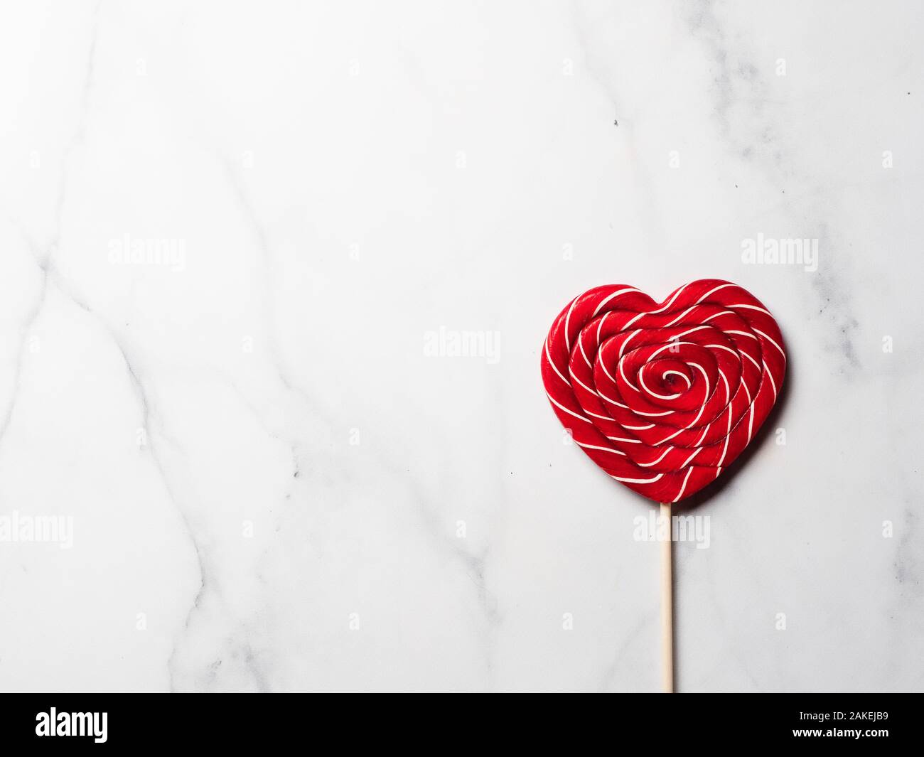 Caramella Dolce cuore su marmo bianco dello sfondo. copia spazio a sinistra. Vista superiore o laici piatta Foto Stock