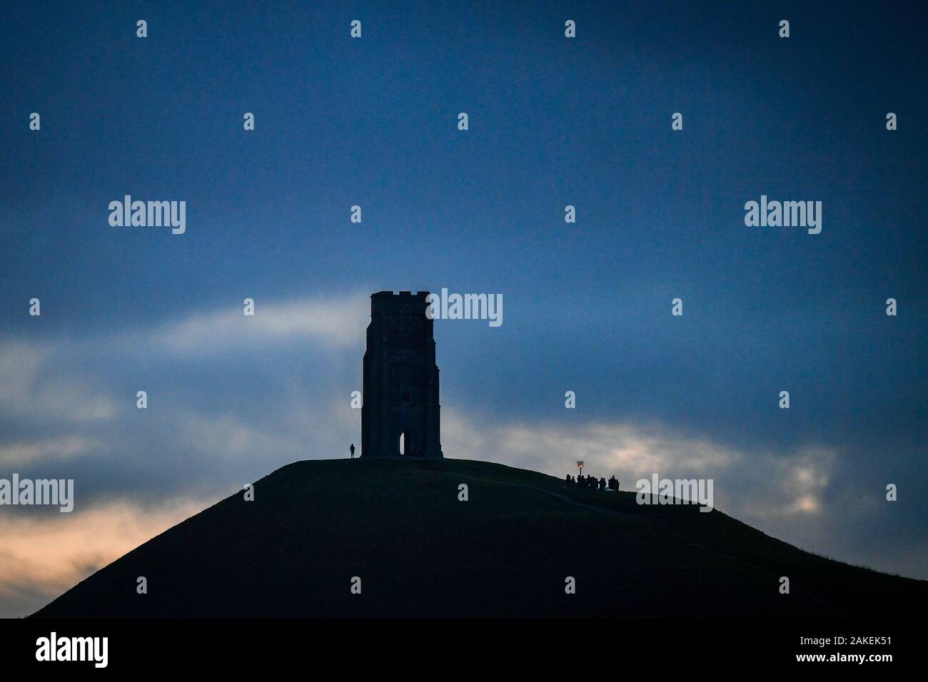 Le persone si radunano all'alba da San Michele la torre in cima di Glastonbury Tor, Somerset, per celebrare 125 anni del National Trust, che è stata fondata nel 1895 a cura di proprietà storica, aree della bella campagna e per fornire accesso a spazi verdi. Foto Stock