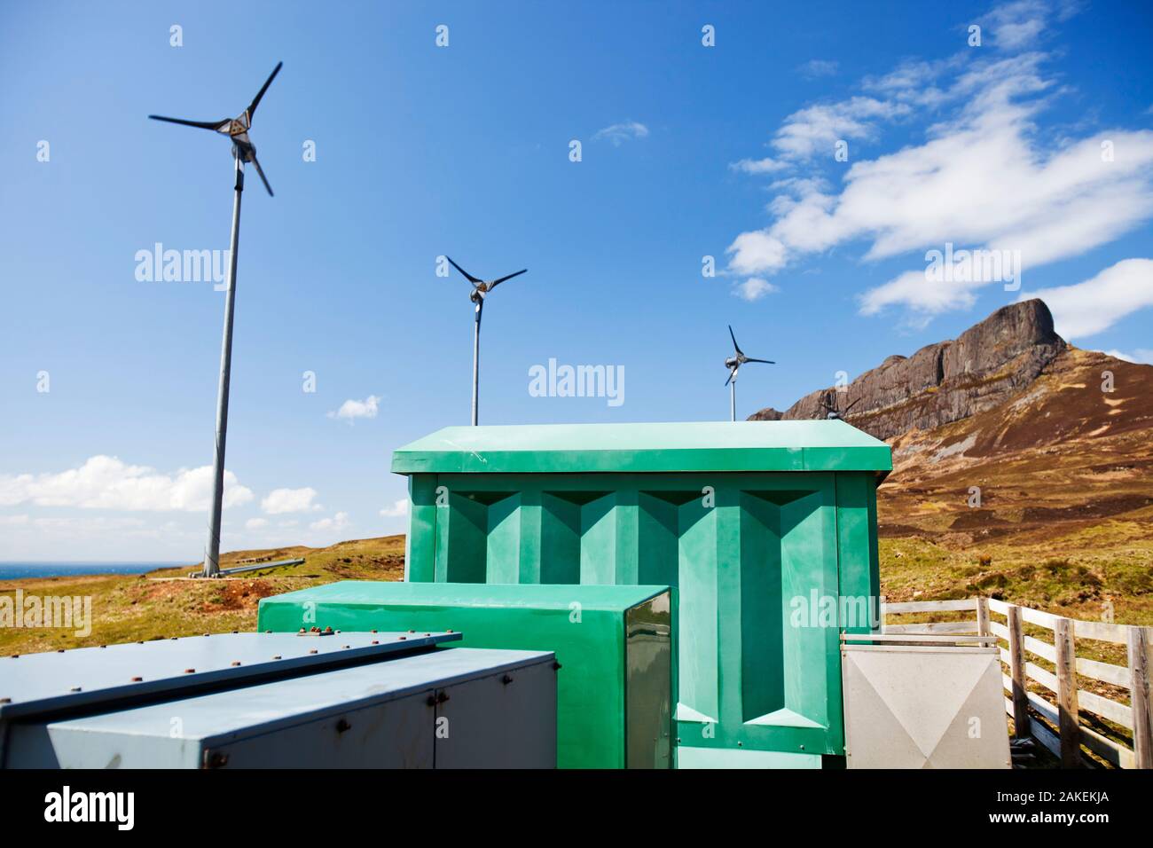 Quattro turbine a vento al di sotto di un Sgurr, Isola di Eigg. Isola di Eigg produce tutta l'energia l'isola nees da fonti di energia rinnovabili. Eigg, Scotland, Regno Unito, maggio. Foto Stock