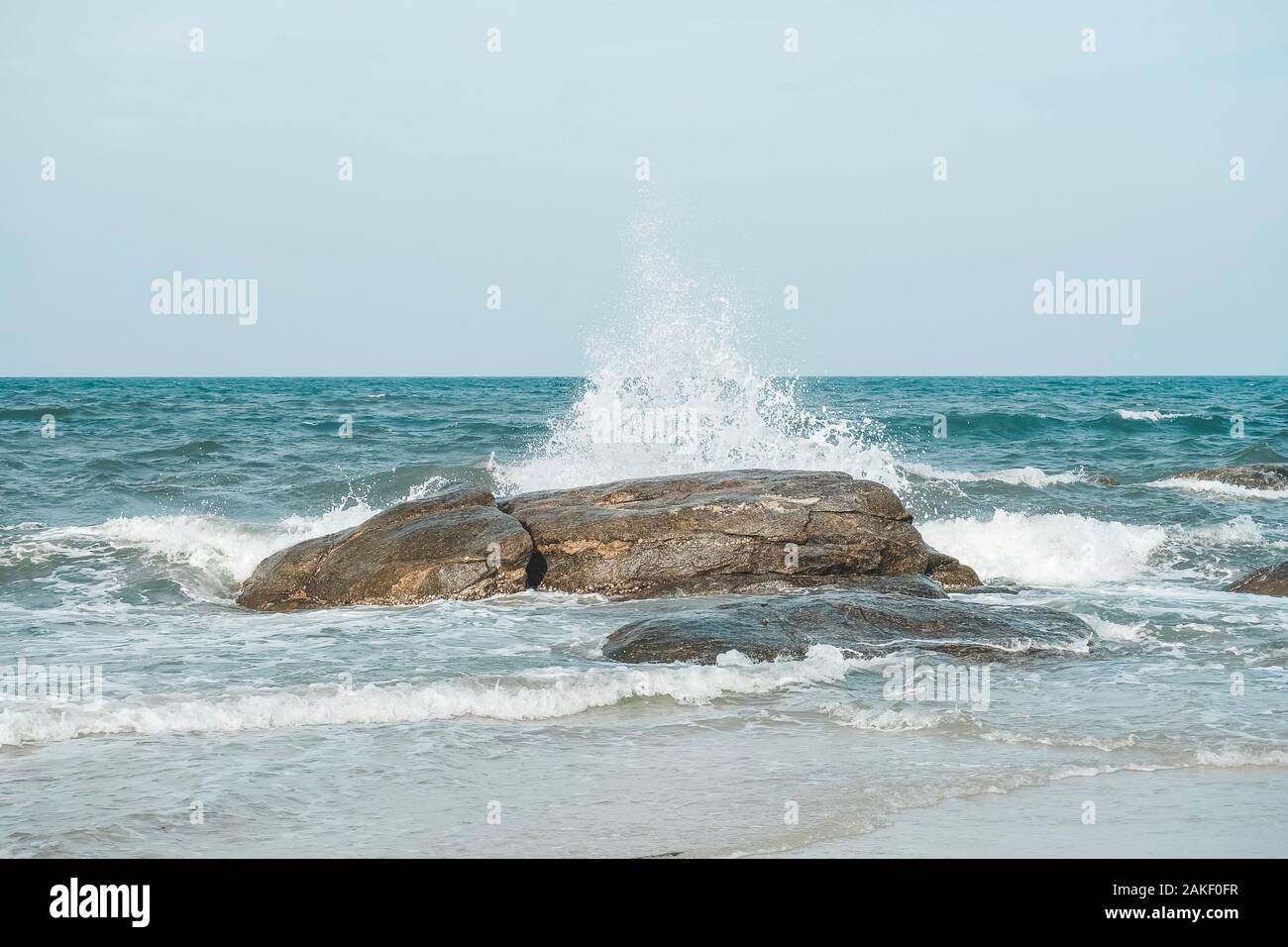 Sea wave e schizzi colpisce la pietra sulla spiaggia di Hua Hin, Prachuap Khiri Khan, Thailandia. Toni pastello. Foto Stock