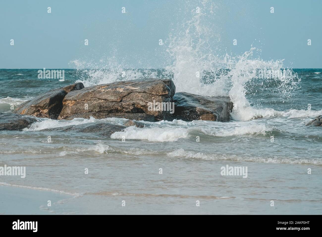 Sea wave e schizzi colpisce la pietra sulla spiaggia di Hua Hin, Prachuap Khiri Khan, Thailandia. Toni pastello. Foto Stock