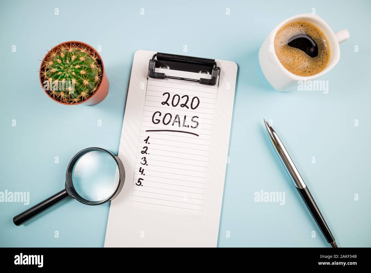 Vista superiore 2020 Elenco degli obiettivi con il notebook e la tazza di caffè sulla scrivania blu. Risoluzioni 2020, Meta, Piano, strategia, cambiare idea concept Foto Stock