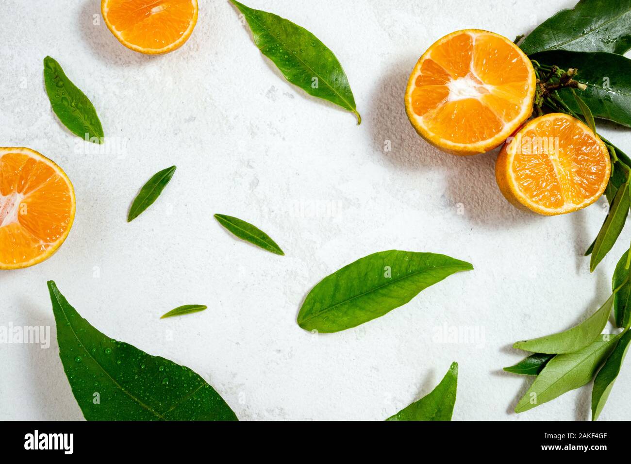 Telaio con foglie verdi e mandarino agrumi sfondo. Mandarino, mandarine, clementina, arancione i frutti con foglie su sfondo bianco. Top v Foto Stock