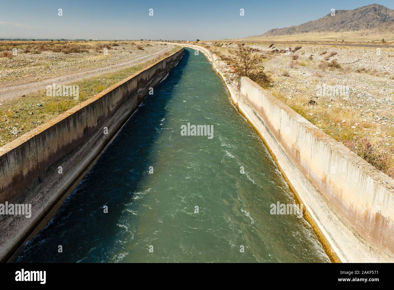 L'acqua che scorre in un canale di irrigazione in Kirghizistan, irrigazione Chuy Provincia Foto Stock