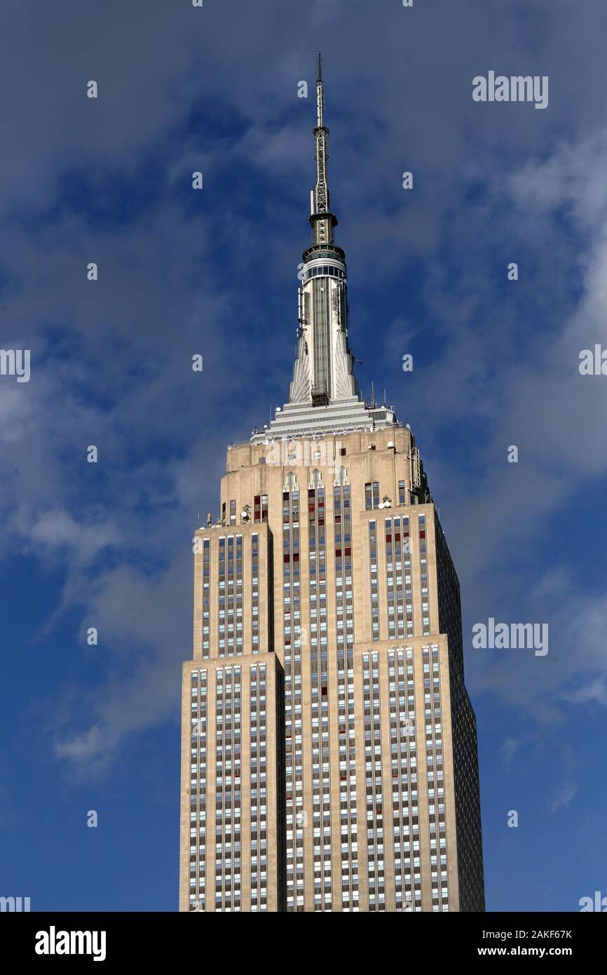 L'Empire State Building contro una parte blu cielo molto nuvoloso in New York, NY Foto Stock