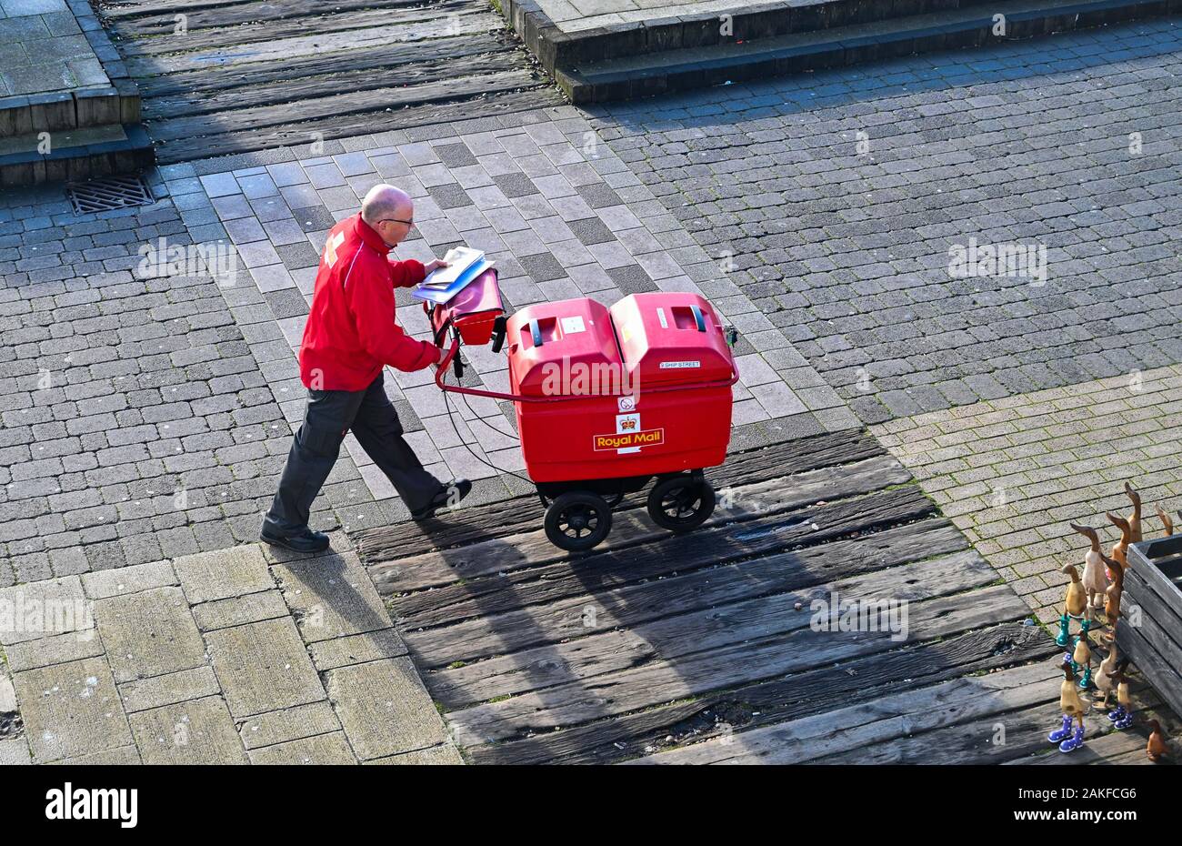 Royal Mail postman che lavora e cammina lungo il lungomare di Brighton UK Foto Stock