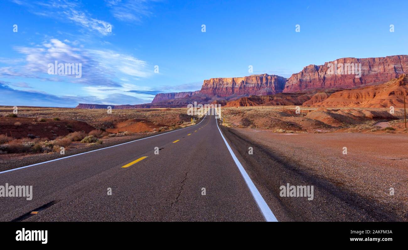 Autostrada del deserto in Northern Arizona con scogliere vermiglio in background. Foto Stock
