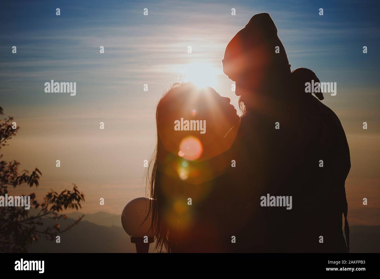 Silhouette giovane amanti abbraccio ed un bacio a sfondo di sunrise Foto Stock