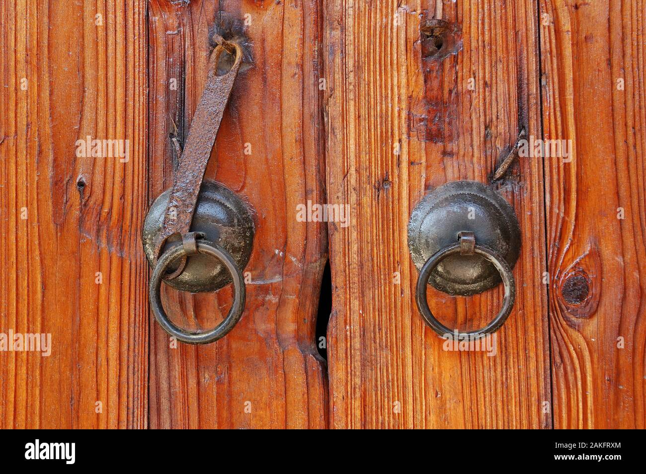 Il tipico cinese tradizionale di legno verniciato porta con il vecchio stile porta metallica battenti su.di solito la vernice della olio di tung oltre il legno nel directio Foto Stock