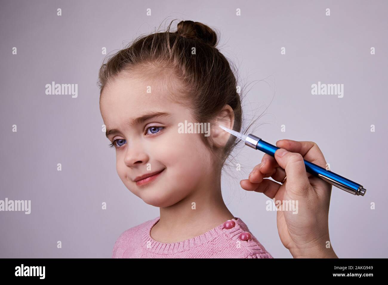 Medico di esaminare la ragazza orecchio medico con torcia a penna. Audiologist esaminando poco paziente con torcia ENT Foto Stock