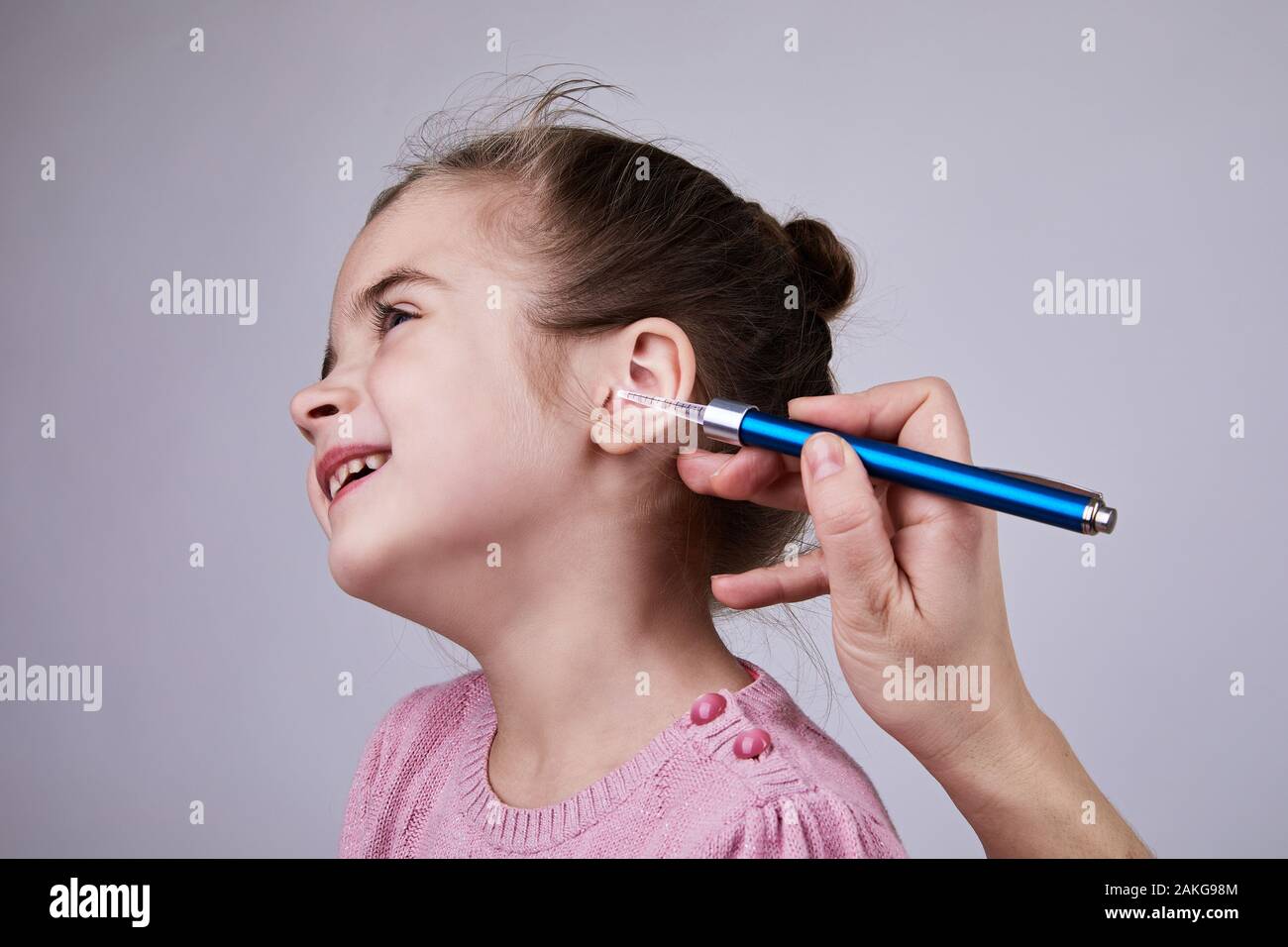 Medico di esaminare la ragazza orecchio medico con torcia a penna. Audiologist esaminando poco paziente con torcia ENT Foto Stock