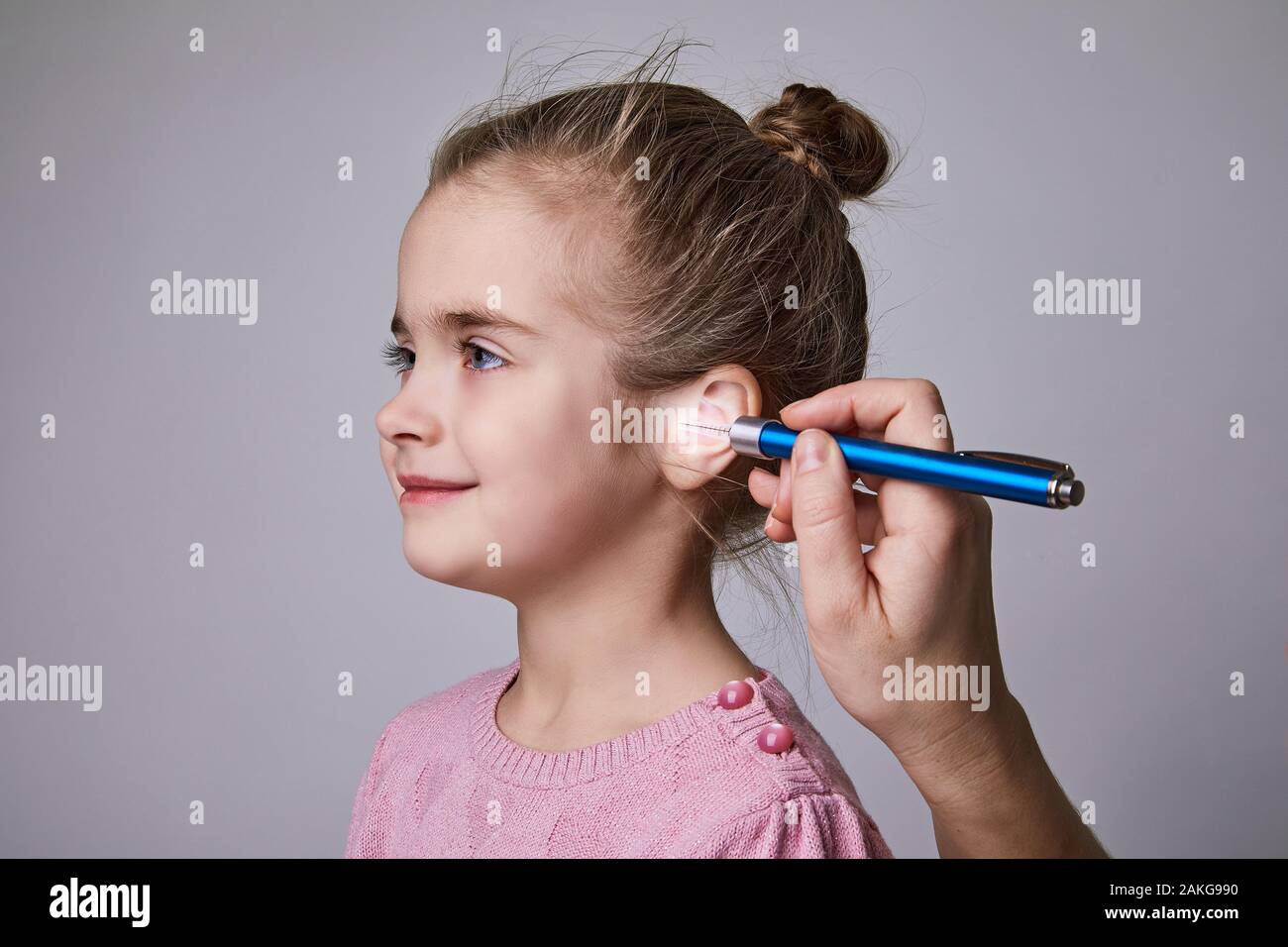 Medico di esaminare la ragazza orecchio medico con torcia a penna. Audiologist esaminando poco paziente con torcia ENT Foto Stock