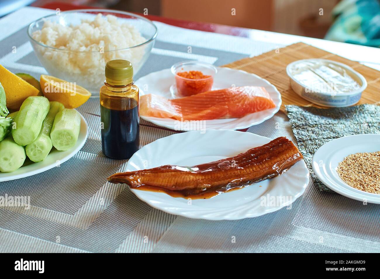 In casa rotoli di sushi preparato. Ingredienti tradizionali prodotti prodotto alimentare sulla home tavolo da cucina pronti per essere preparati. Cibo asiatico dello sfondo. Foto Stock