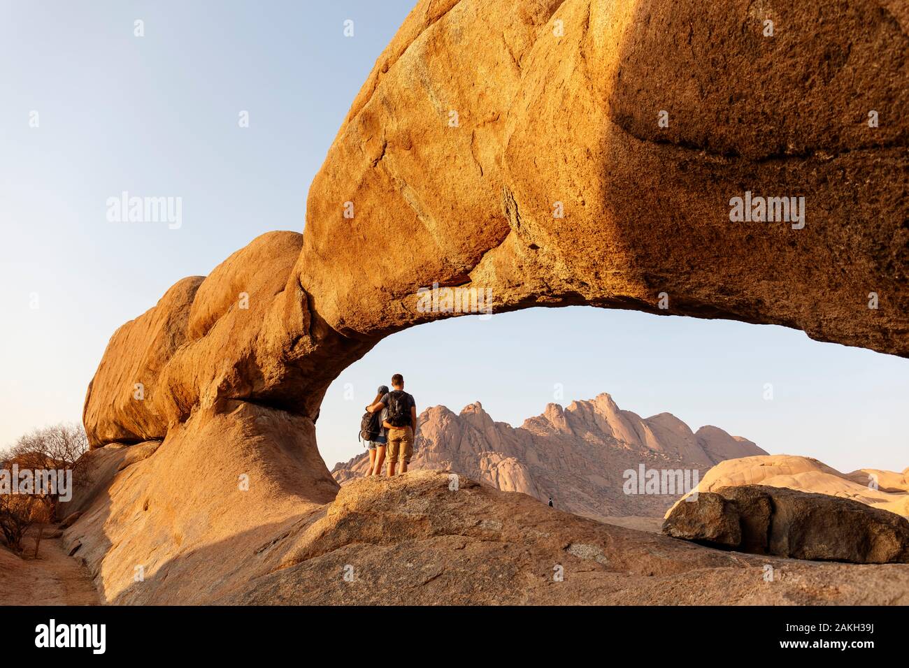 La Namibia, Erongo provincia, Spitzkoppe, i turisti al di sotto dell'arco Foto Stock