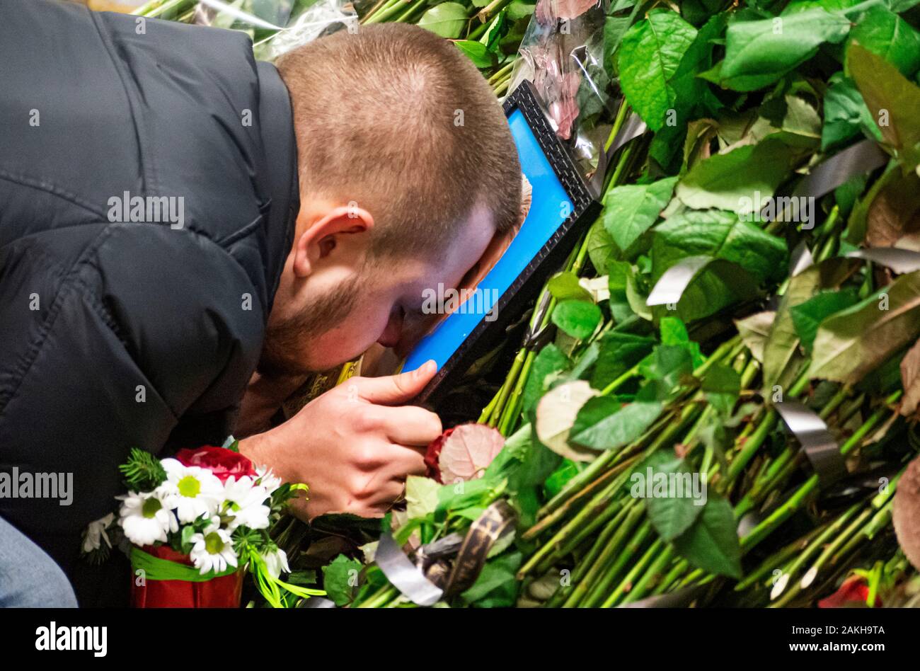 In una spontanea memorial angolo dell'aeroporto Borispyl, il marito baci un ritratto di sua moglie, il defunto assistente di volo Yulia Sologub. Per l'Ucraina International Airlines aereo si schianta su Gennaio 8, 2020 poco dopo il decollo da Imam Khomeini Aeroporto in Tehran, Iran. Foto Stock