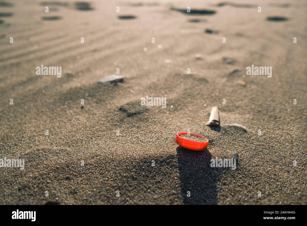 Rosso bottiglia di plastica il sughero di sabbia sul mare, ecosistema inquinato,microplastics Foto Stock