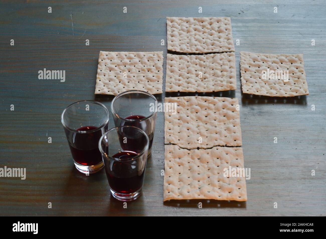 La cena del Signore con pane a forma di croce e tre piccole tazze di vino Foto Stock