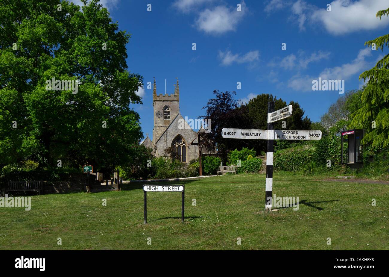Villaggio scena con verde vecchio cartello stradale e chiesa, Islip oxfordshire Foto Stock