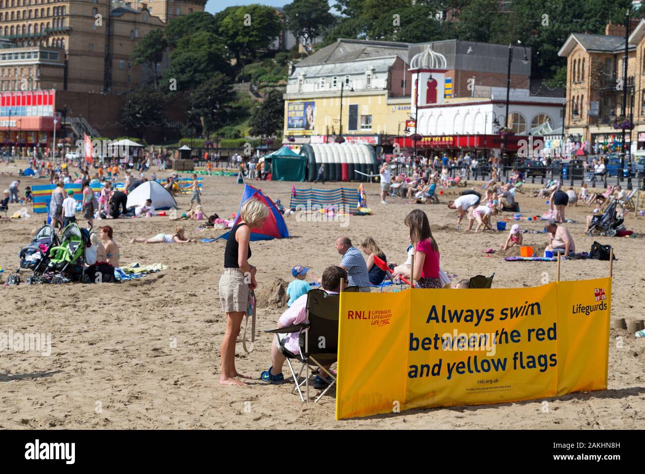 Messaggio di sicurezza dei nuotatori su un banner sulla spiaggia di Scarborough. "Nuota sempre tra le bandiere rosse e gialle." Foto Stock