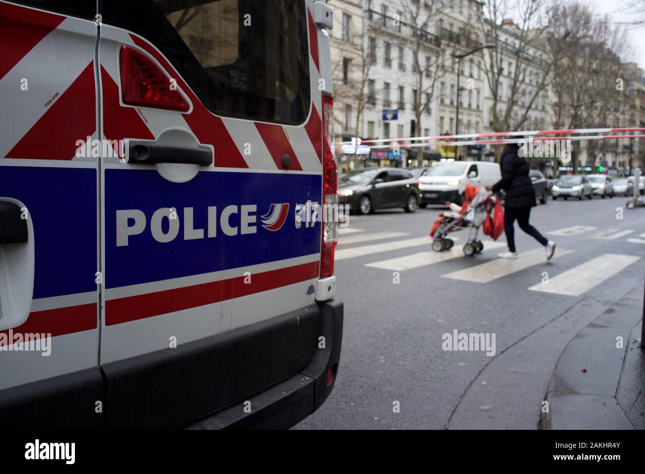 La polizia francese Van e blocco di Cordon road al traffico in previsione delle manifestazioni di protesta del governo le riforme dei sistemi pensionistici, come donna con push-sedia attraversa road, viaggi interruzioni durante lo sciopero (la grève), Boulevard Barbès (vicino alla stazione dei treni Gare du nord), 75018, Paris, Francia, 9 gennaio 2020 Foto Stock