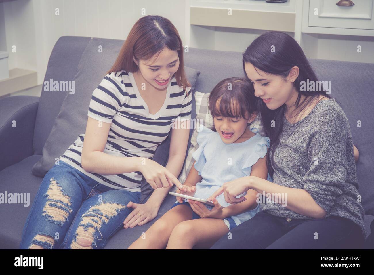 Madre, Zia e kid avente tempo lerning insieme con l'utilizzo di tablet a casa con relax e felice sul lettino, l educazione e il concetto di stile di vita. Foto Stock