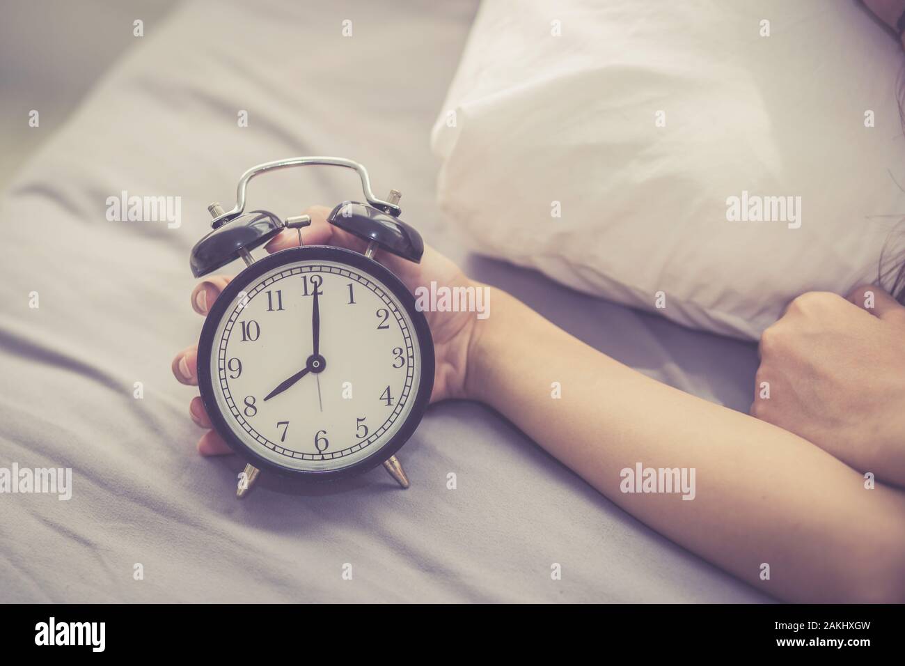 Closeup asian giovane donna disattivare la sveglia di buon mattino per dormire con ragazza con sveglia, tempo e concetto di stile di vita. Foto Stock