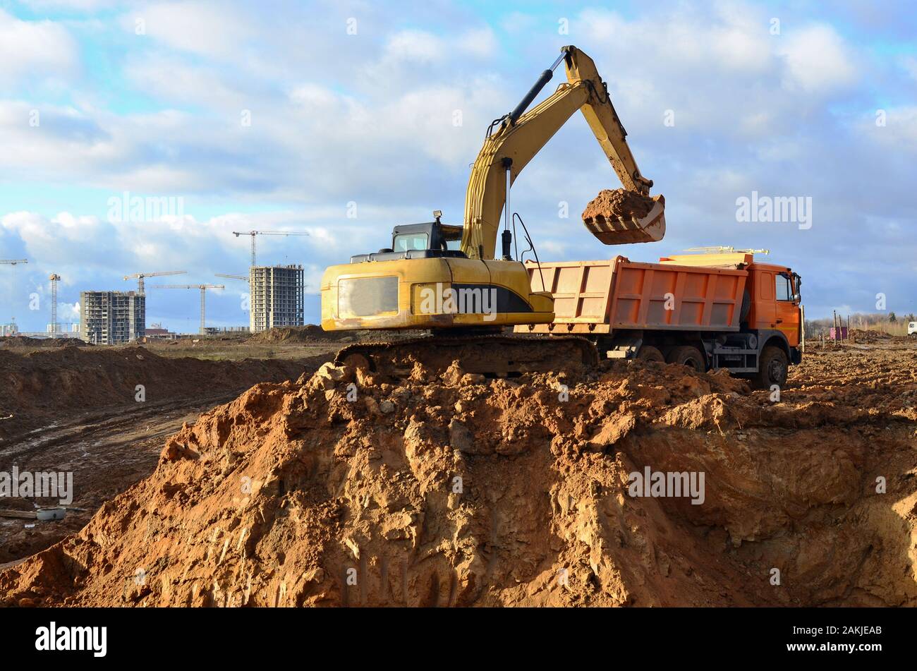 Carico escavatore la sabbia per il pesante autocarro con cassone  ribaltabile sul sito in costruzione. Escavatori