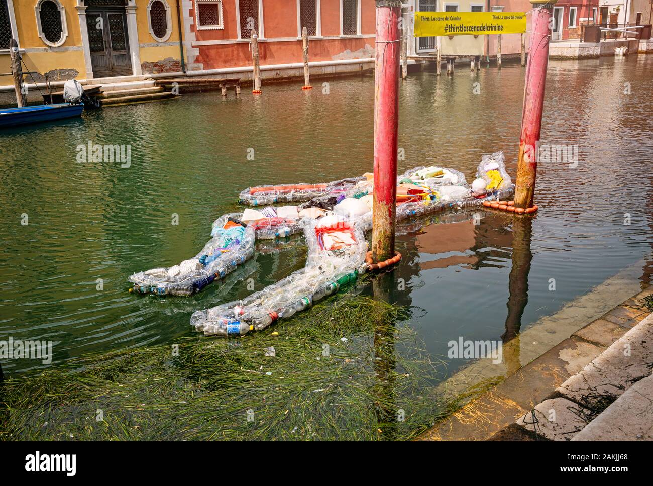 Chioggia, Venezia, Veneto, Italia Agosto 1, 2019. Esposizione di un uomo di bottiglie di plastica è situato su un canale di Chioggia Foto Stock