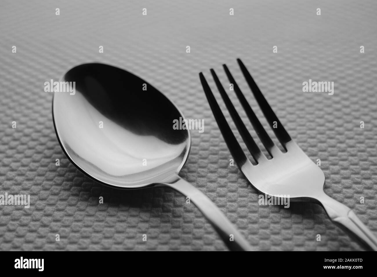 Argento Moderno in acciaio inox cucchiaio e forchetta su un tavolo bianco. Foto Stock
