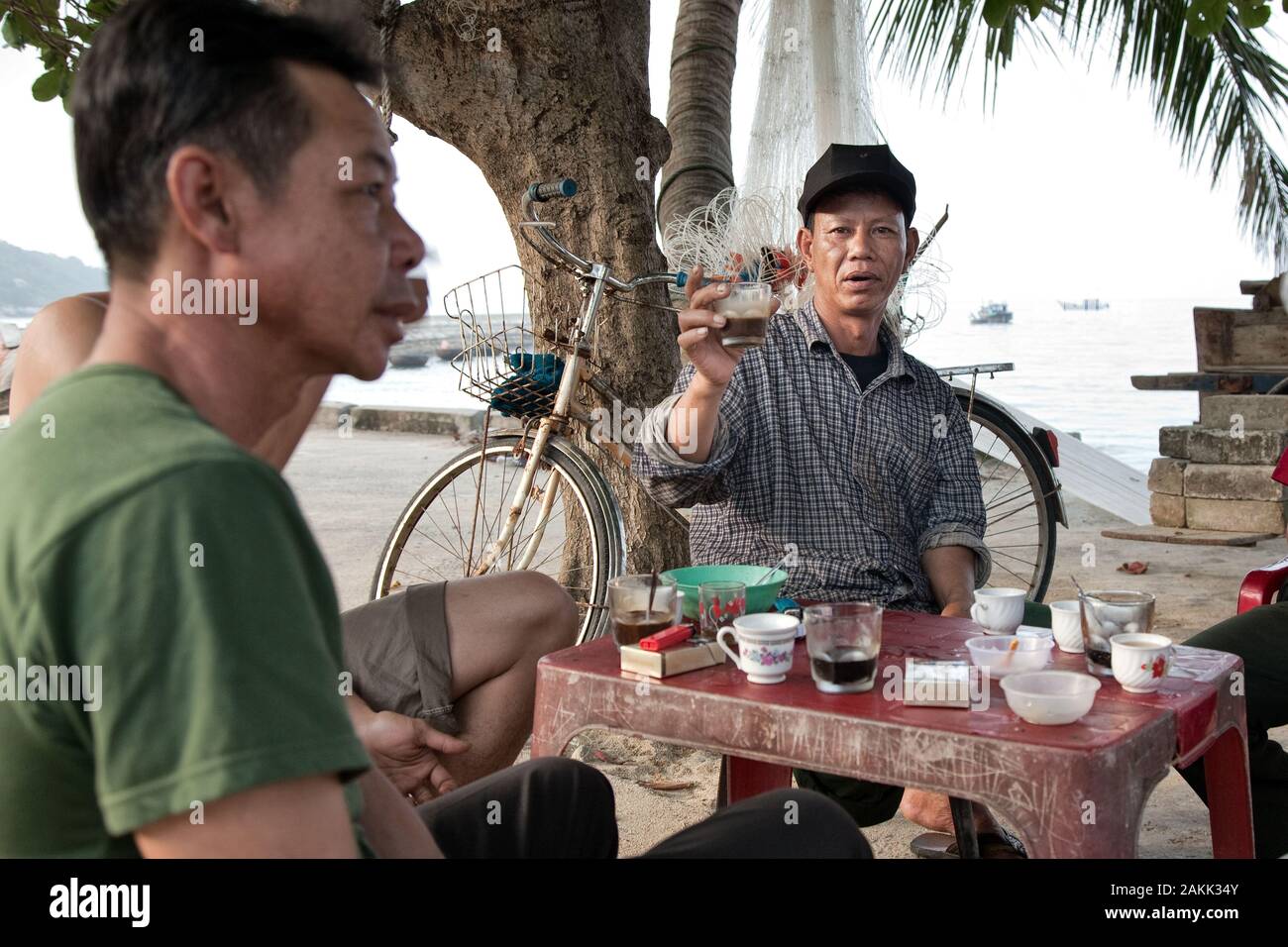 I pescatori vietnamiti bere il caffè sulla banchina del porto, Cham Islands Foto Stock