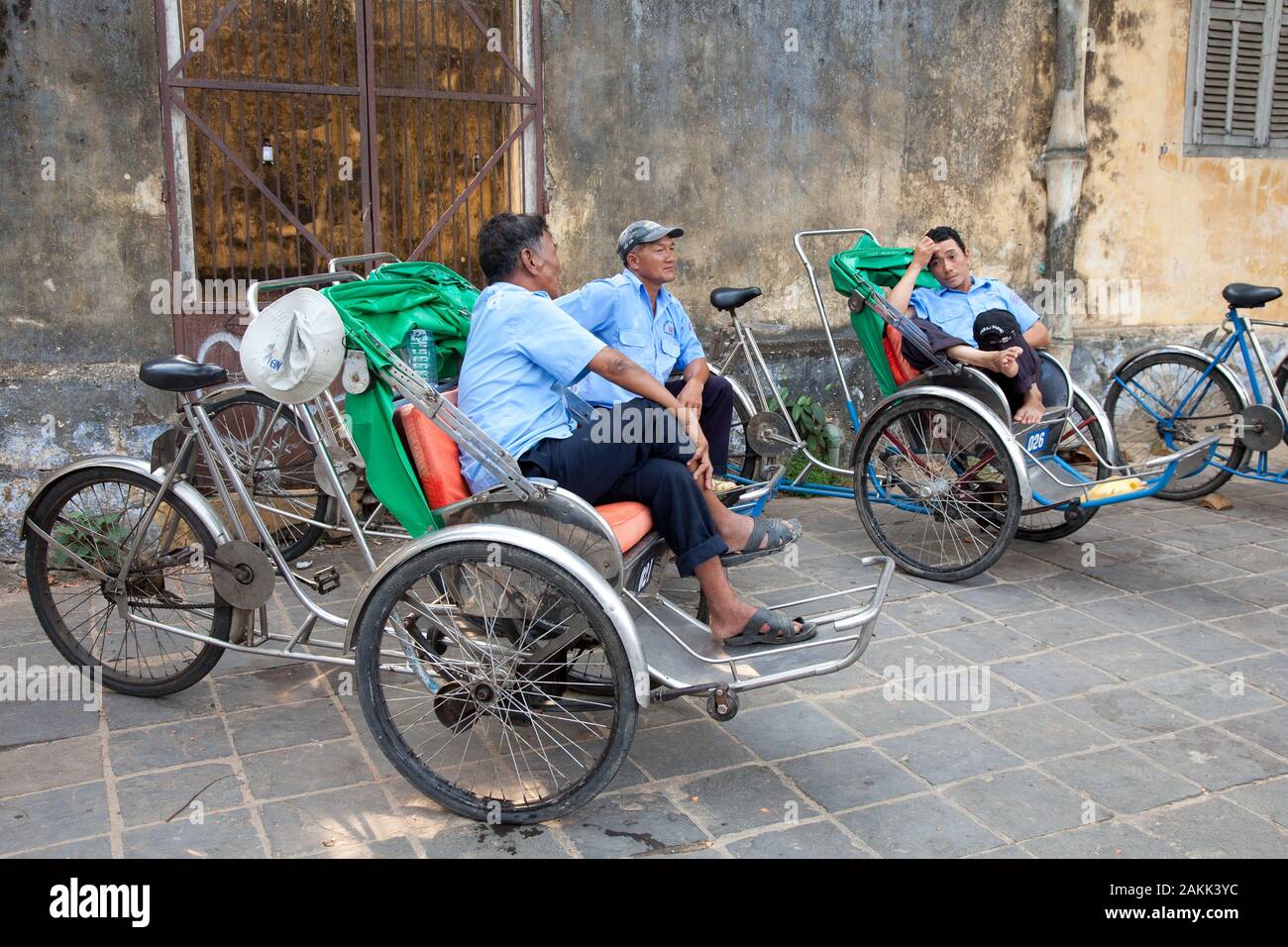 I conducenti di risciò si parlano socialmente mentre aspettano nuovi clienti Foto Stock