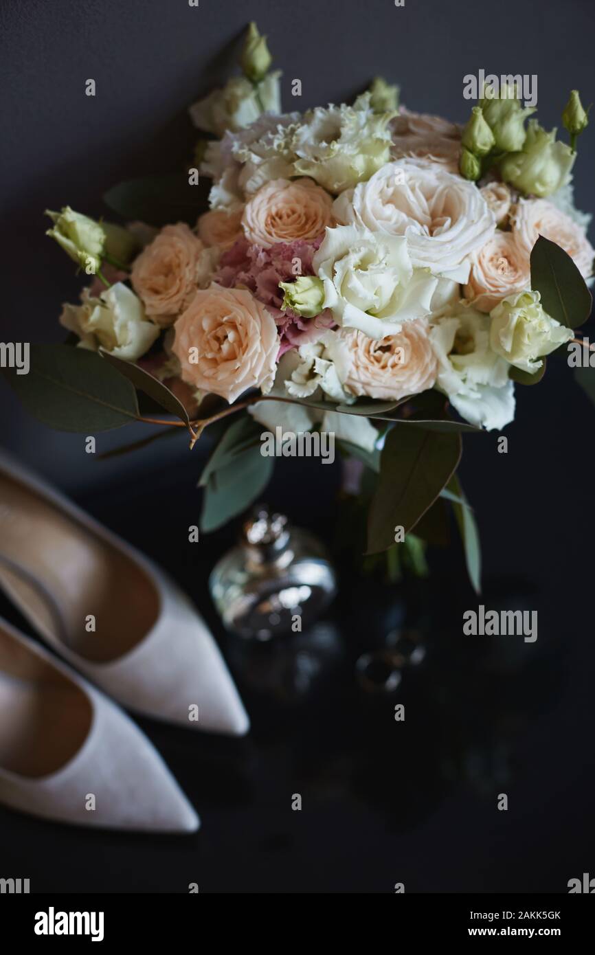 Bouquet di rose fresche, peonie, eucalipto fiori in rosa pastello e colori crema e altri accessori per la sposa. Gli anelli di nozze nuziale, Foto Stock