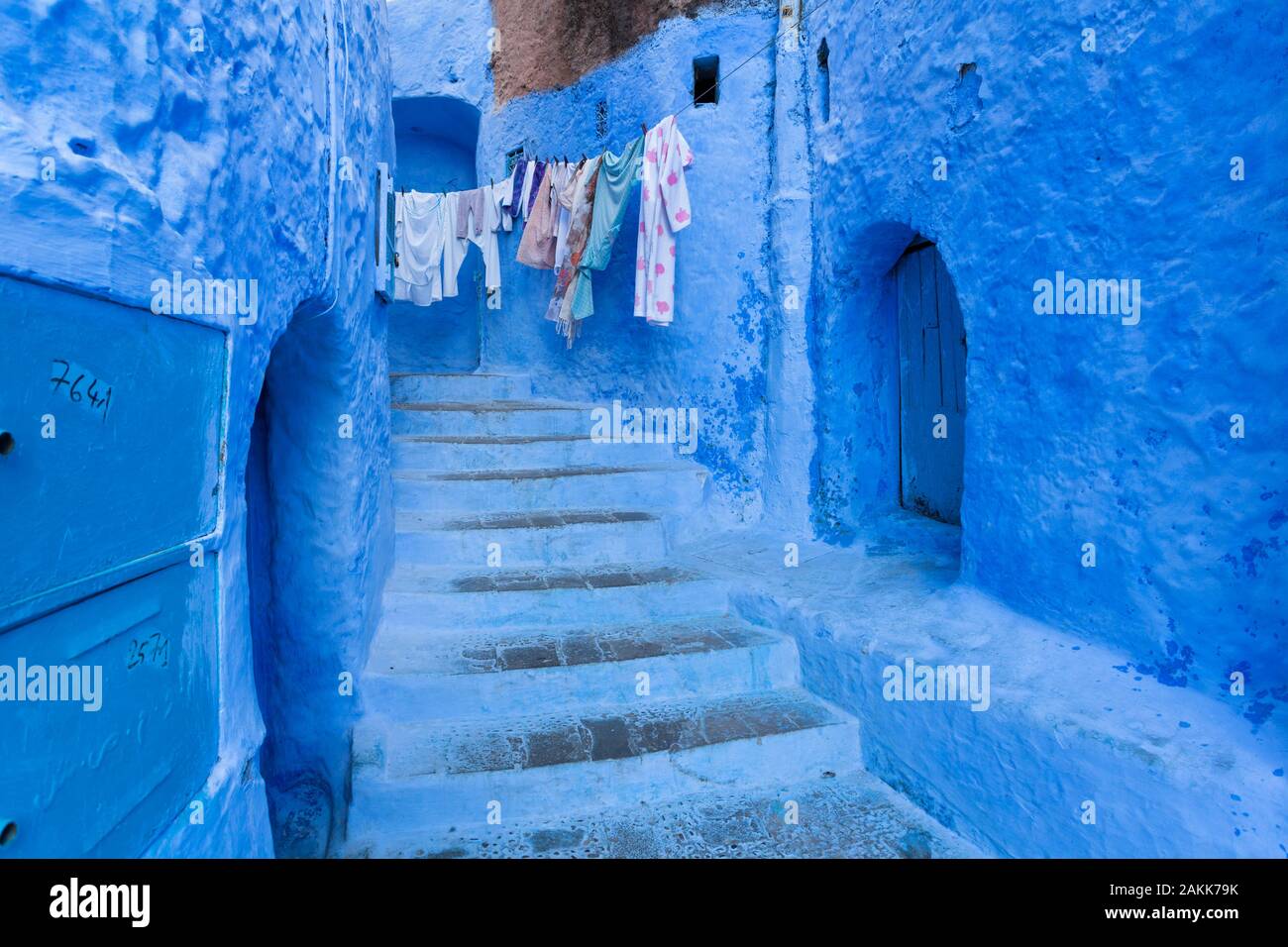 Portali, rampa di scale e la biancheria appesa sulla linea di abbigliamento nella medina di Chefchaouen (noto anche come Chaouen), Marocco Foto Stock